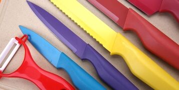 Set,Of,Colorful,Knives,On,Wooden,Cutting,Board