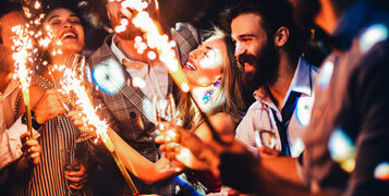 Cropped,Shot,Of,Young,Friends,Holding,Sparklers,At,A,Party